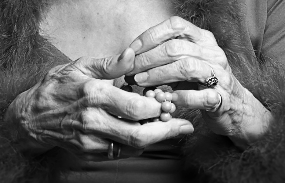 Detailaufnahme: Hände einer älteren Frau mit Perlen und Ringen